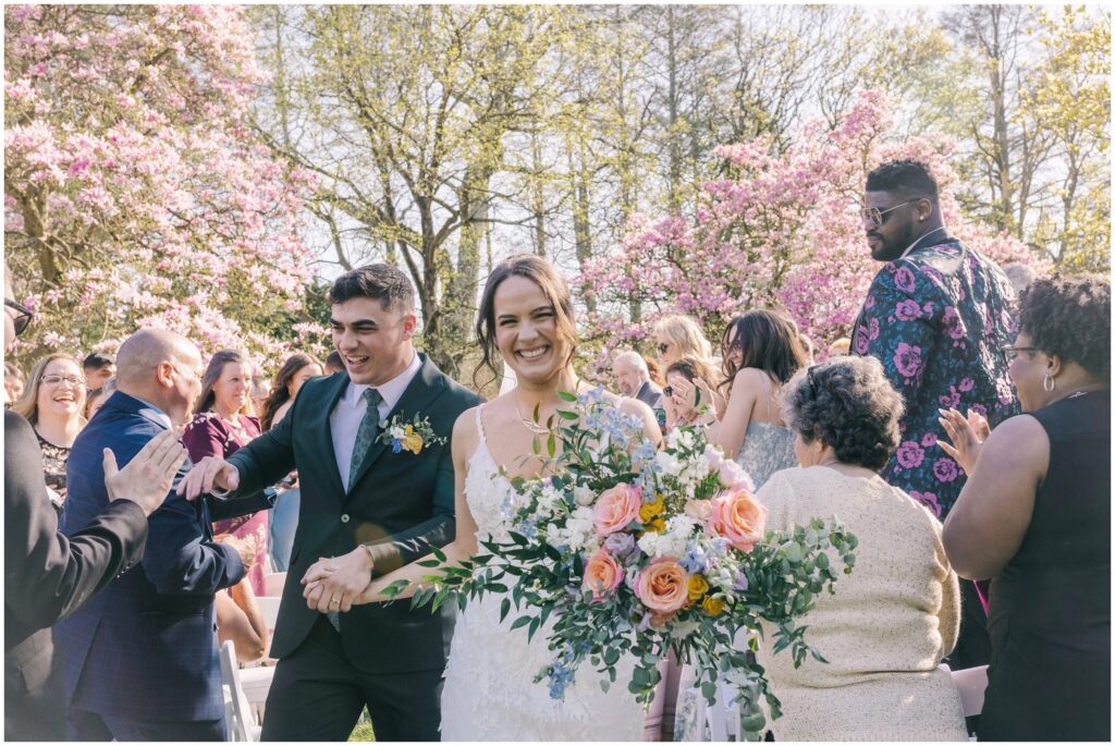 Candid springtime wedding photos of bride and groom walking down the aisle